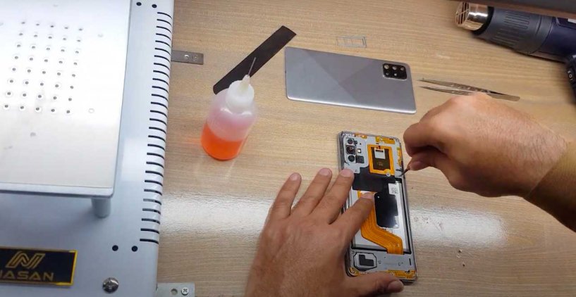 Специалист извлекает батарею из самсунг А71