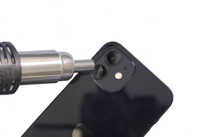 Мастер удаляет поврежденное стекло с камеры